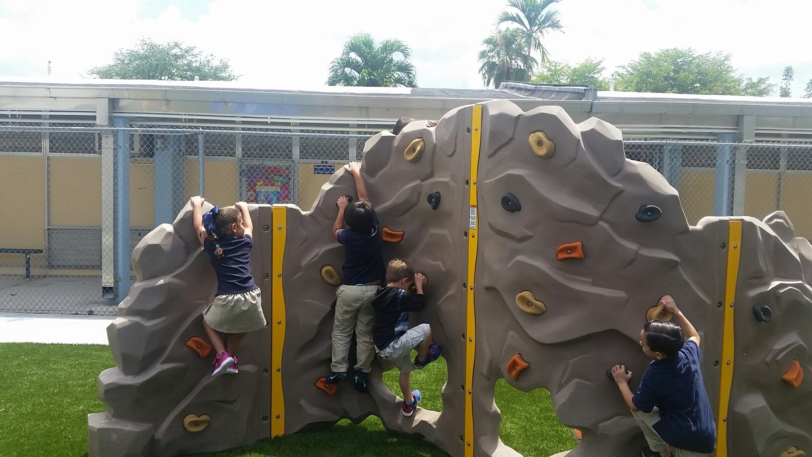 Children climbing on a rock wall structure on a playground