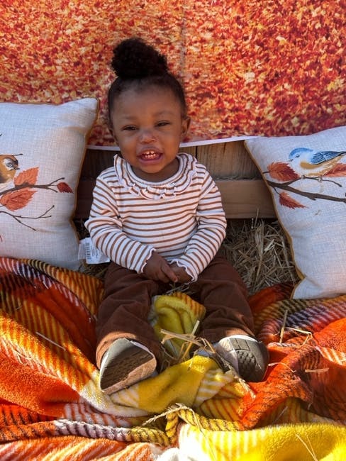 Child sitting on blankets with pillows