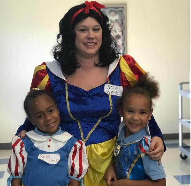 Person dressed as Snow White with two children in costumes