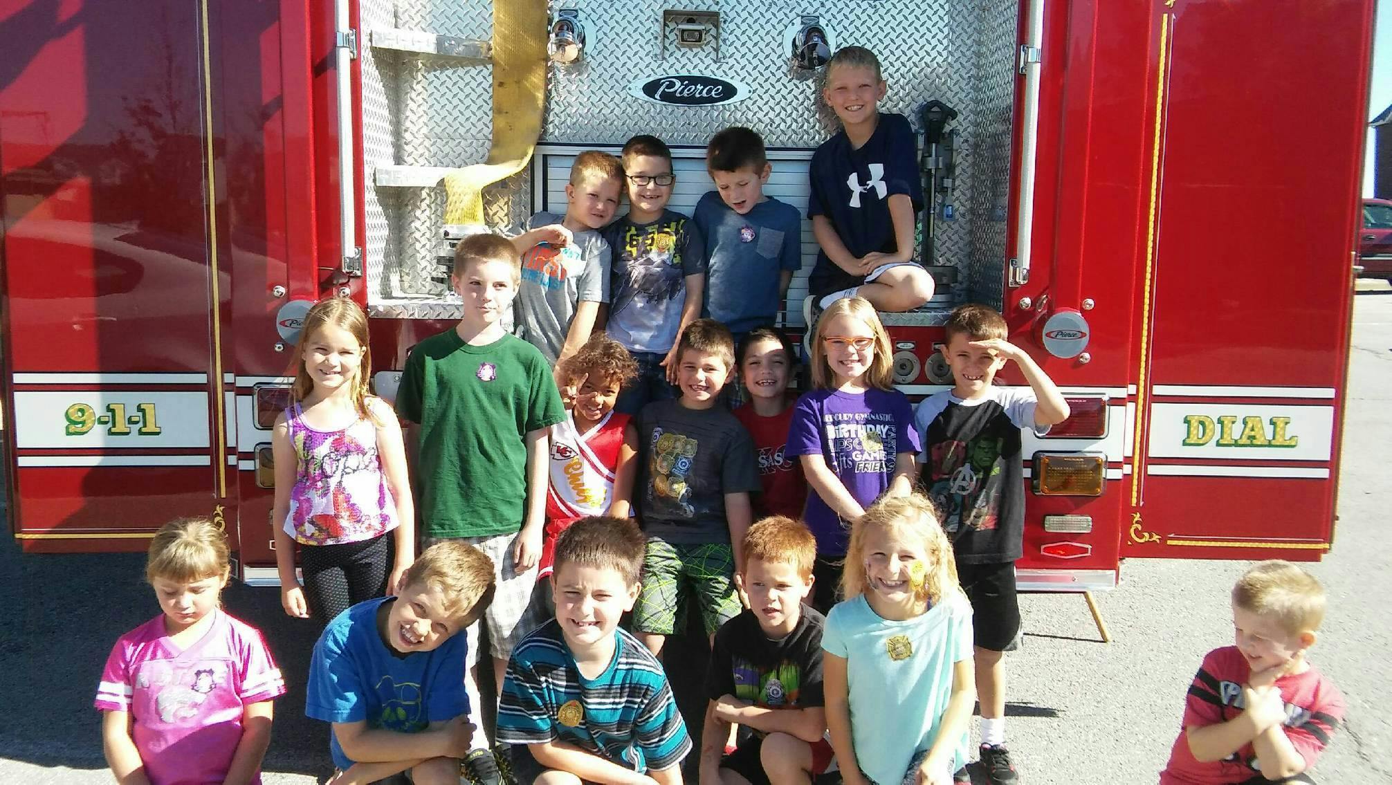 Group of children posing in front of a fire truck