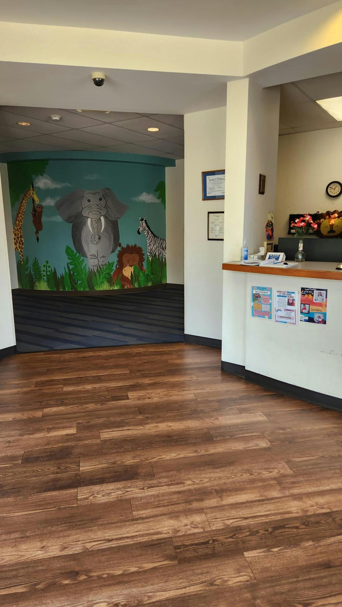 Room with a jungle mural on the wall and a reception desk