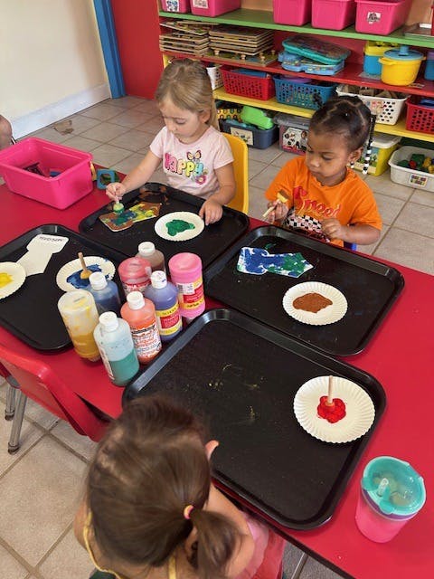 Three children painting at a table