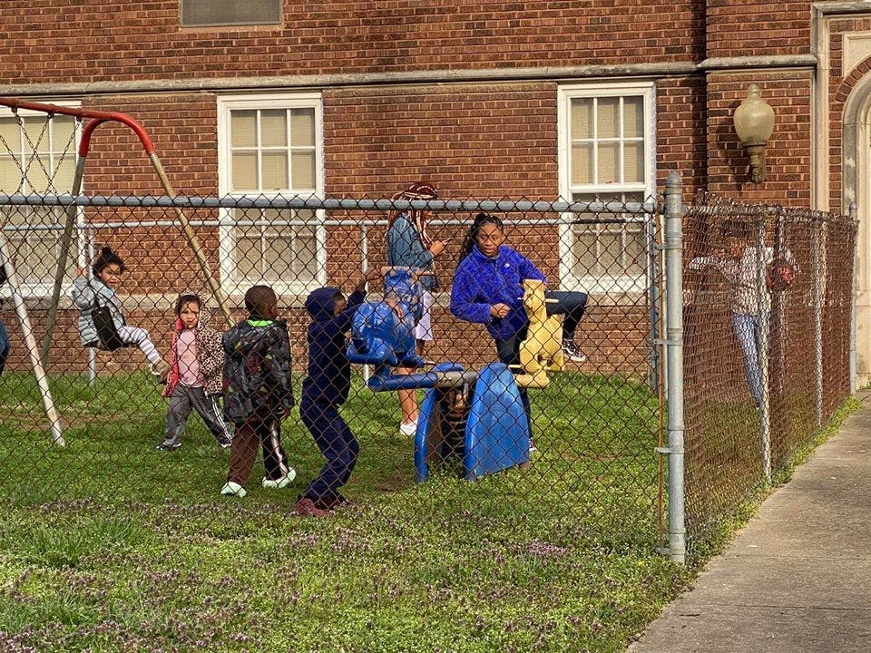 Children playing on a swing set and other playground equipment