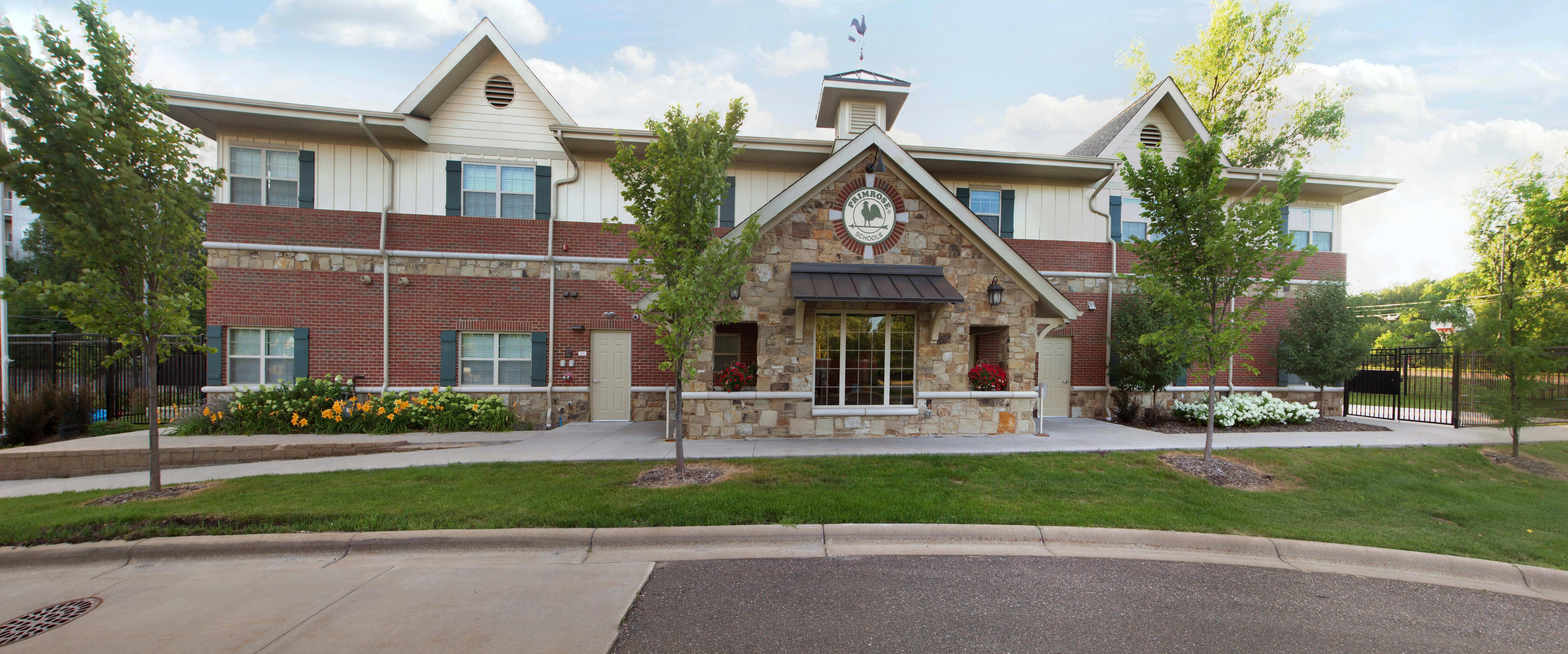 Exterior of a building with brick and stone, a sign reading "Primrose Schools"