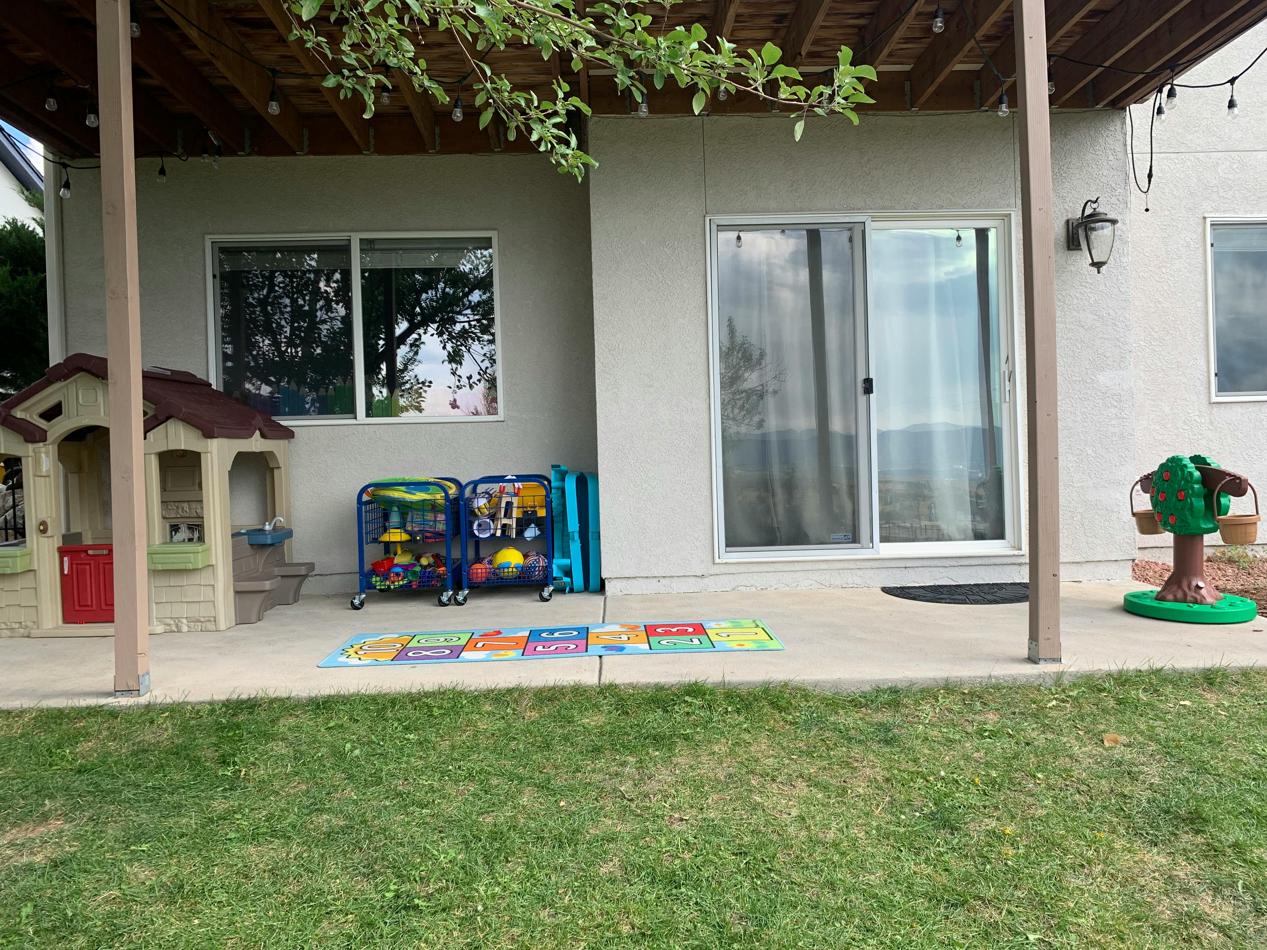 Patio with a playhouse, toy storage, and a sliding glass door