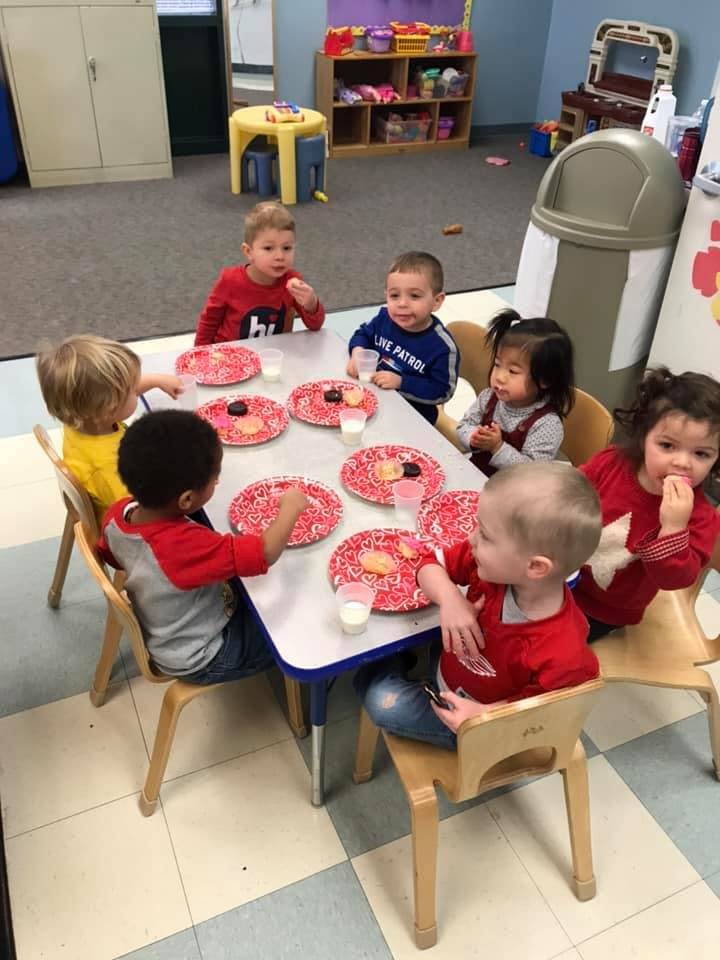 Children sitting at a table with plates and cups