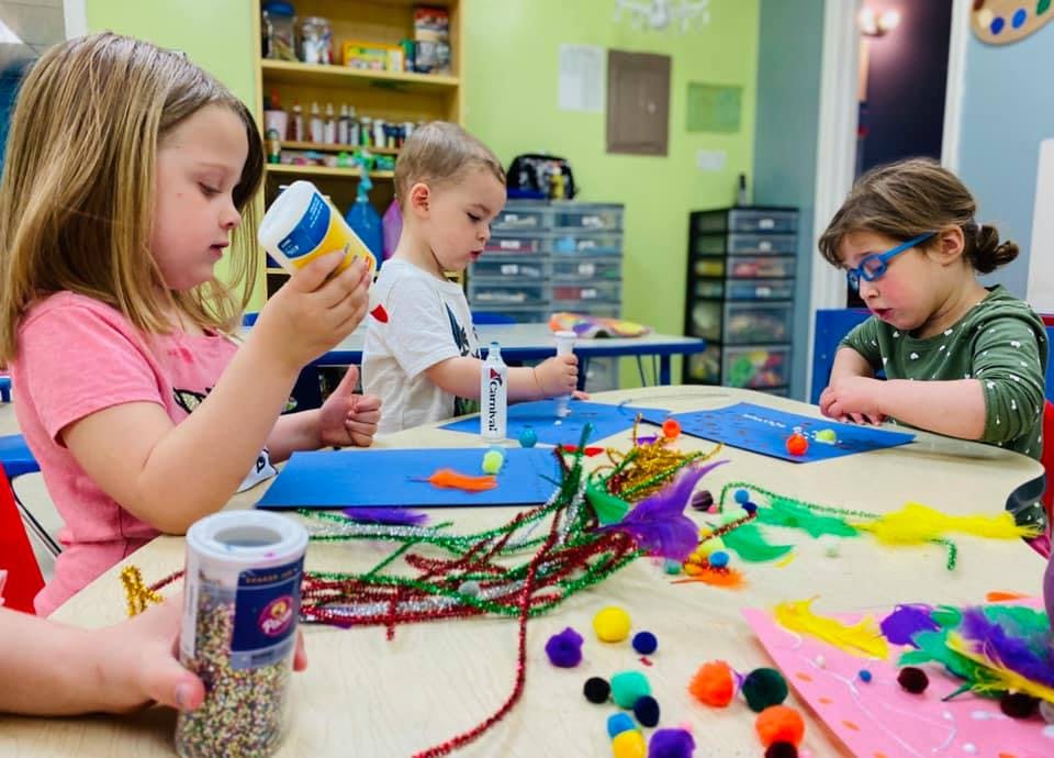 Three children doing crafts at a table