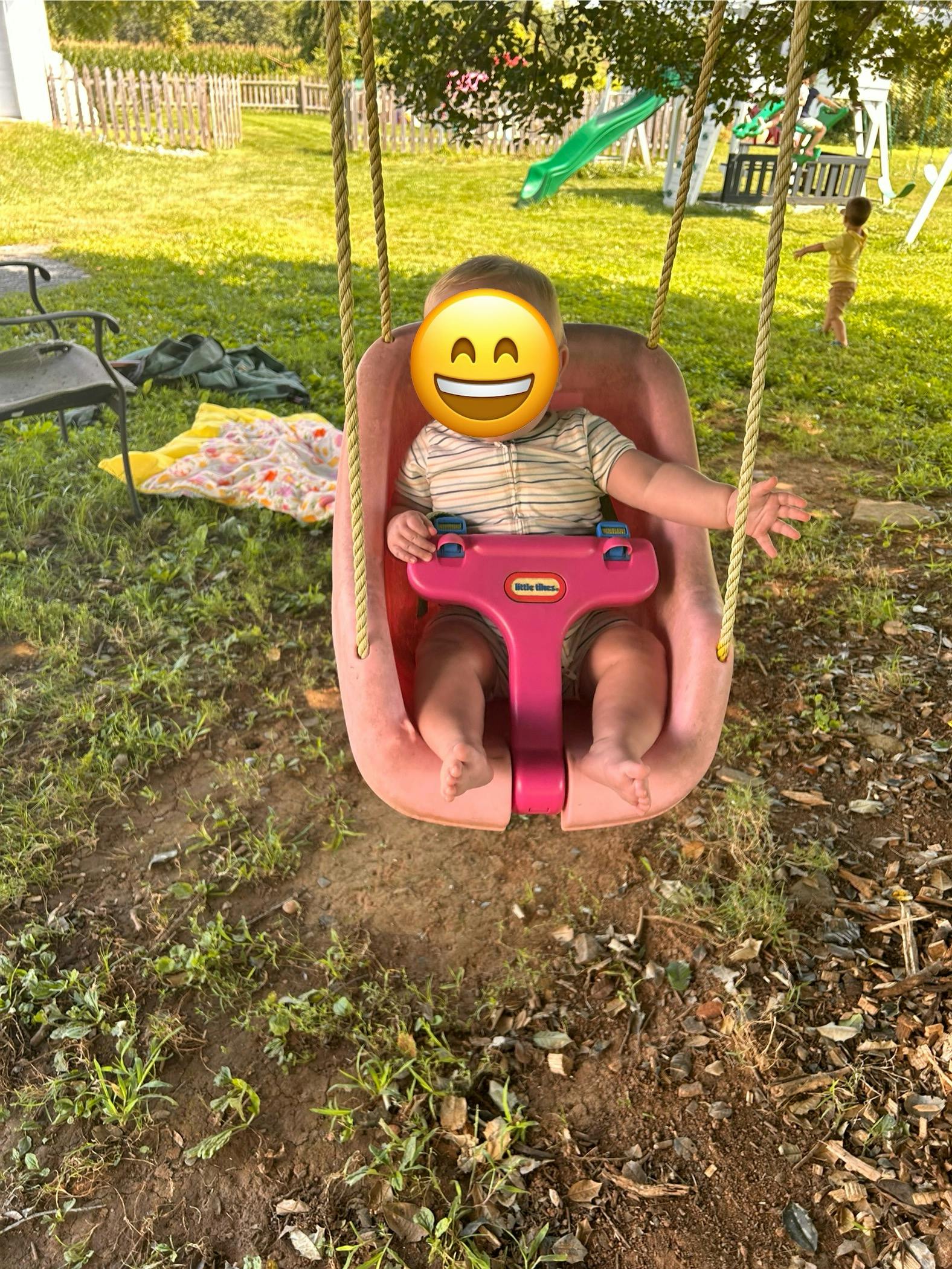 Child in a pink swing seat outdoors