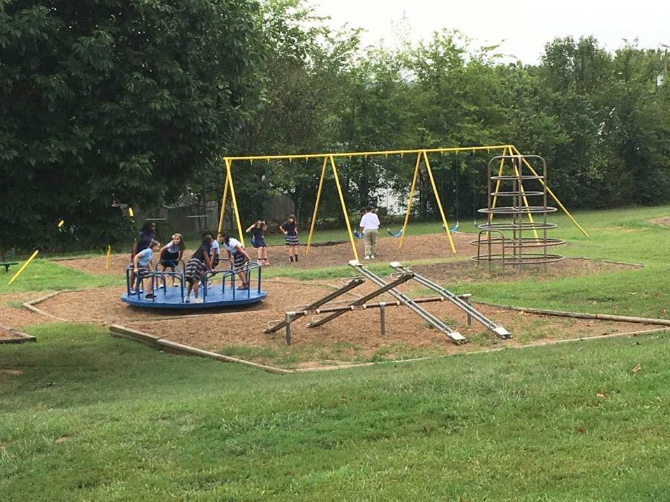 People on a merry-go-round and swings on a playground
