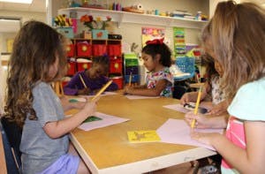 Children drawing at a table in a classroom