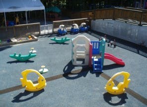 Outdoor playground with slides, swings, and spring riders