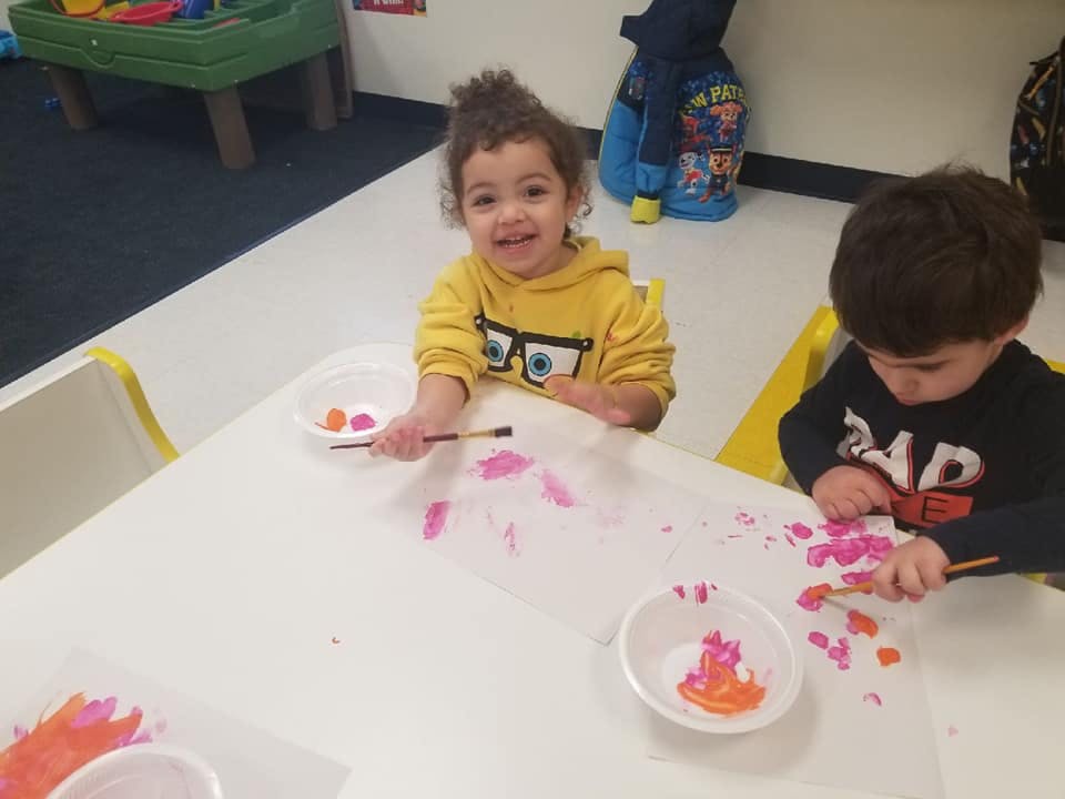 Two children painting at a table