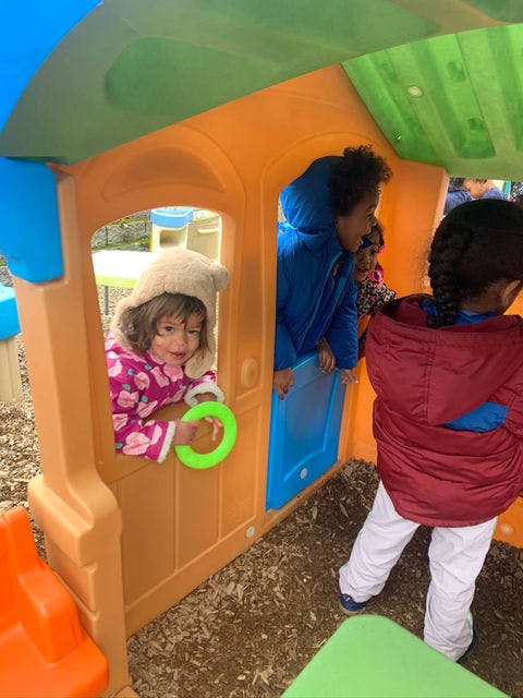 Children playing in a plastic playhouse