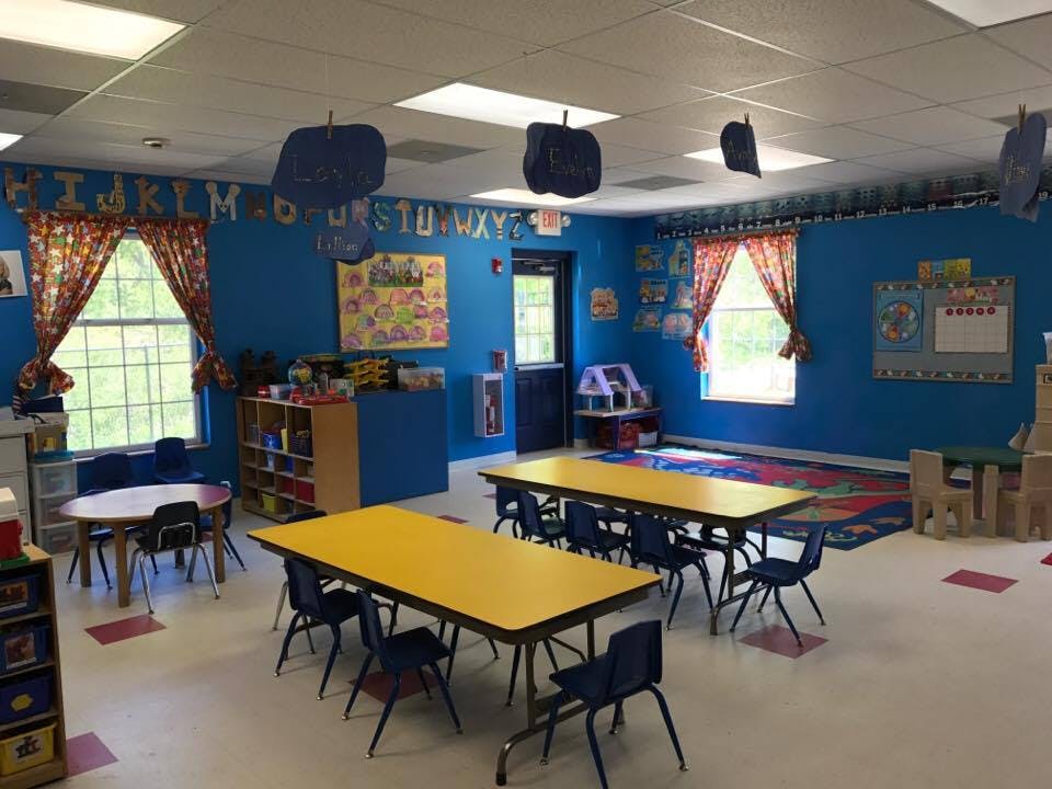 Classroom with blue walls, yellow tables, and small chairs