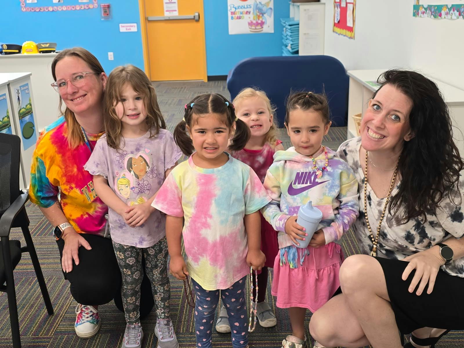 Two people with five children in a classroom