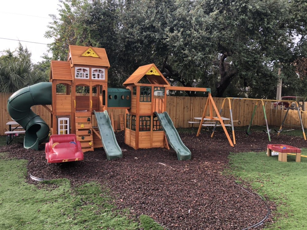 Wooden playground with slides, swings, and a tube slide