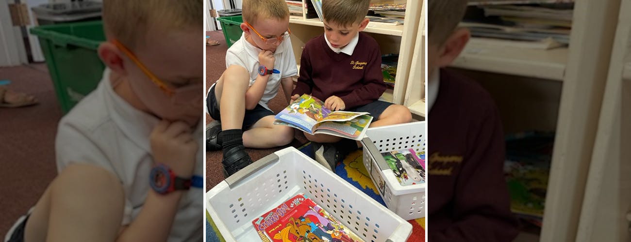 Two children sitting on the floor reading a book