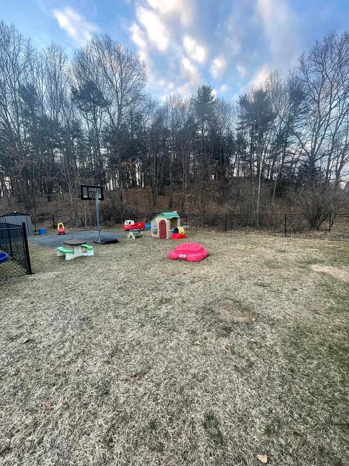 Outdoor play area with a basketball hoop, playhouse, and sandbox