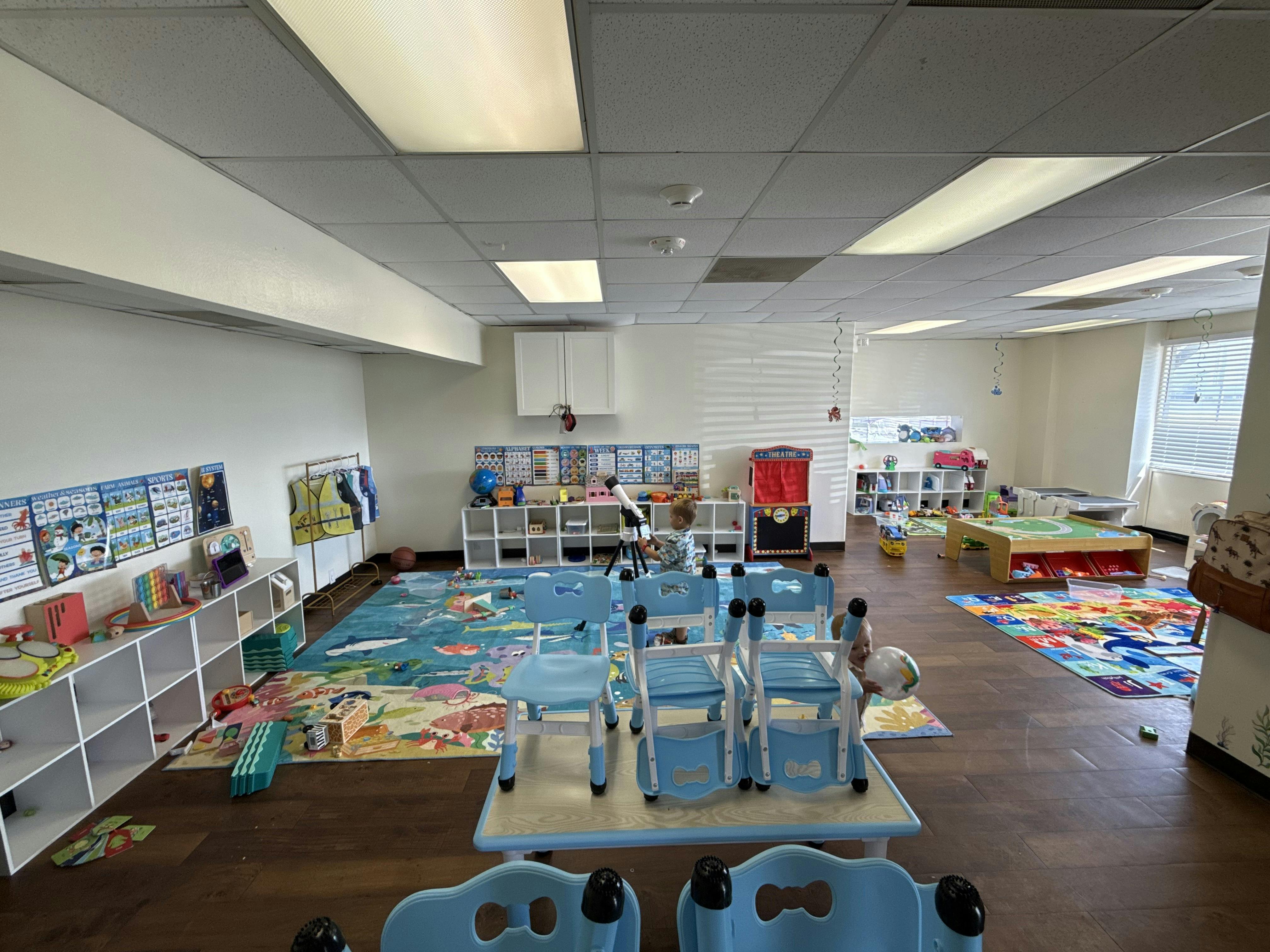 Child looking through a toy telescope in a preschool classroom