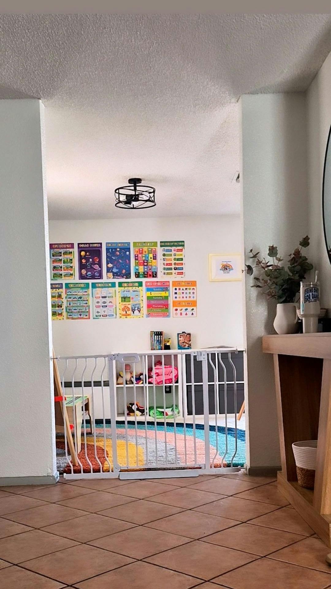 Child safety gate in a doorway leading to a room with educational posters