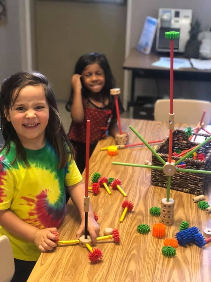 Two children playing with building toys at a table