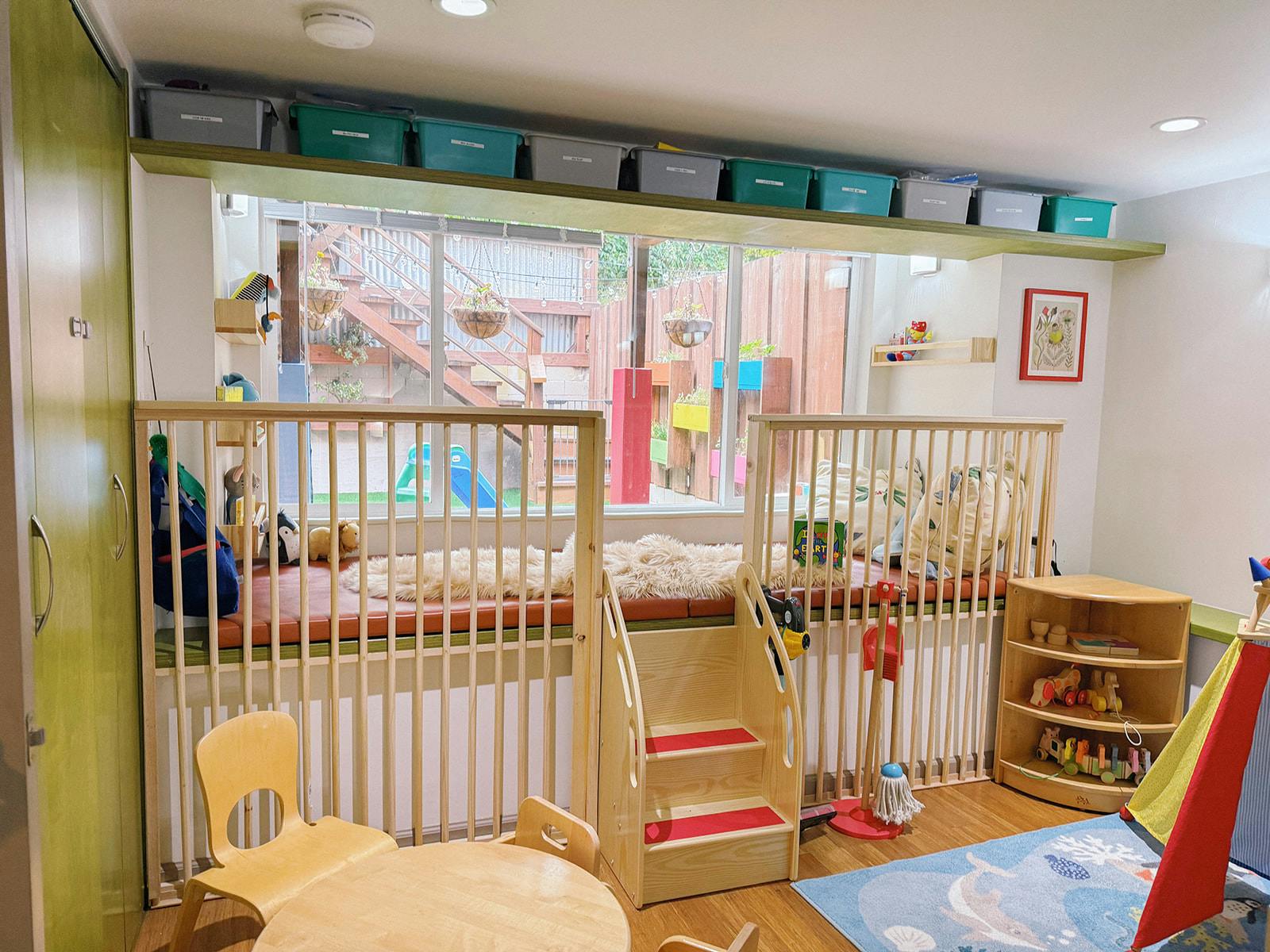 Playroom with a window seat, wooden safety gates, and small chairs