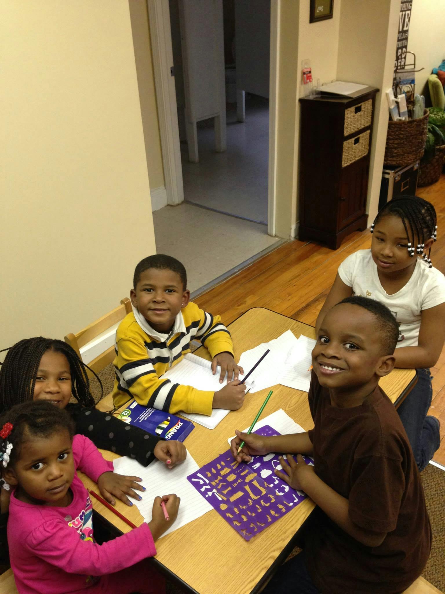 Children drawing and writing at a table