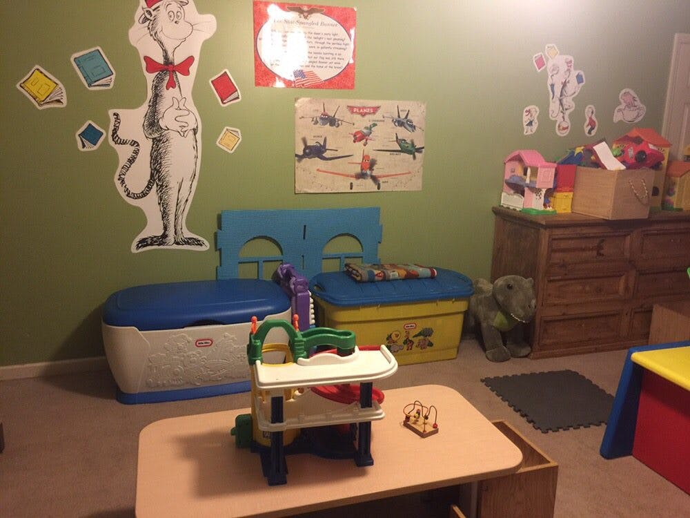 Playroom with toys, storage bins, and wall decorations