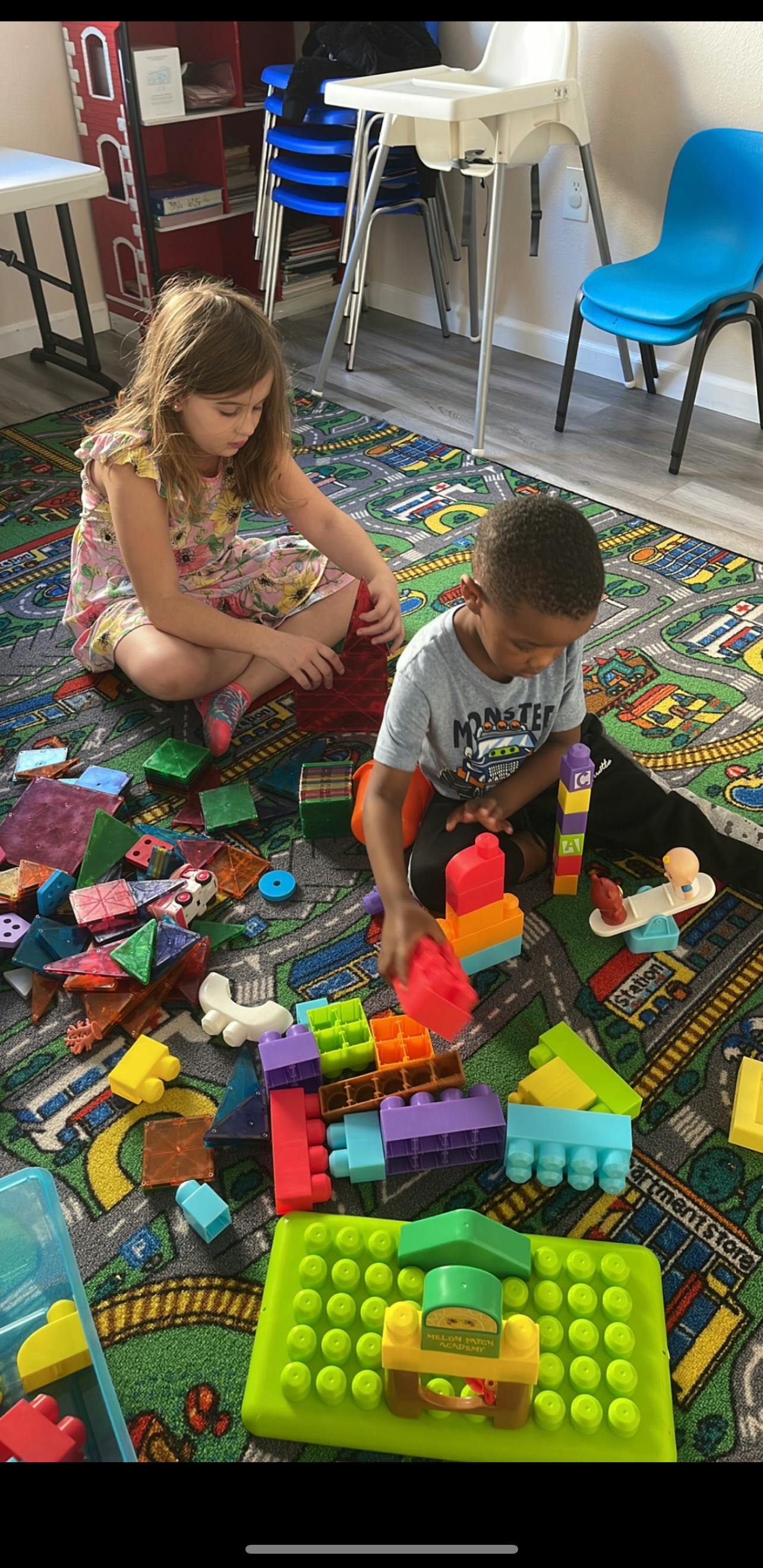 Two children playing with building blocks on a rug