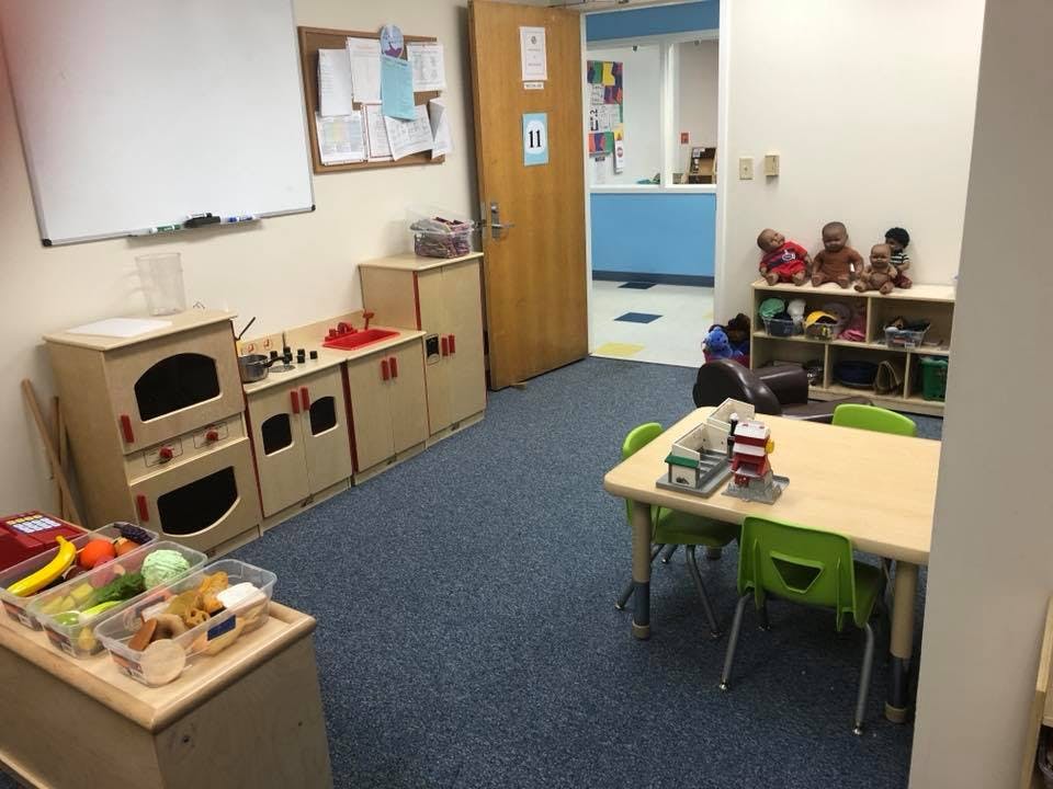 Classroom with play kitchen, table, and chairs