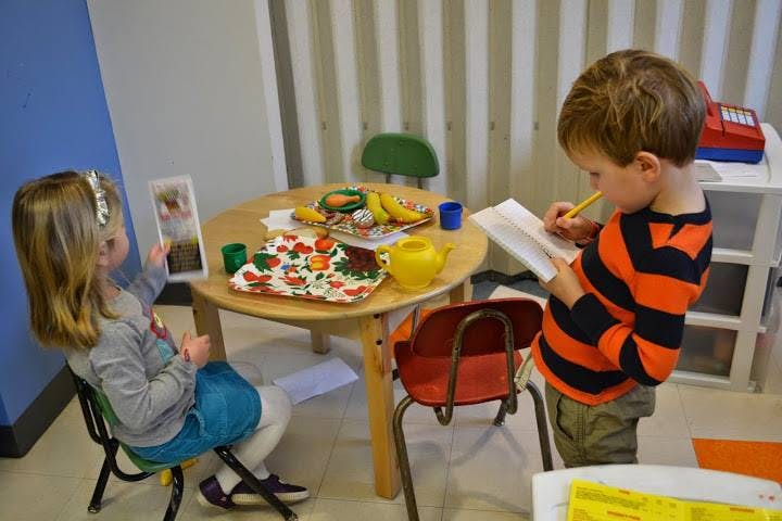 Two children playing at a small table