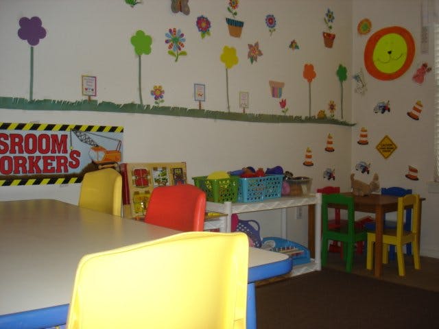 Classroom with small tables and chairs, decorated walls