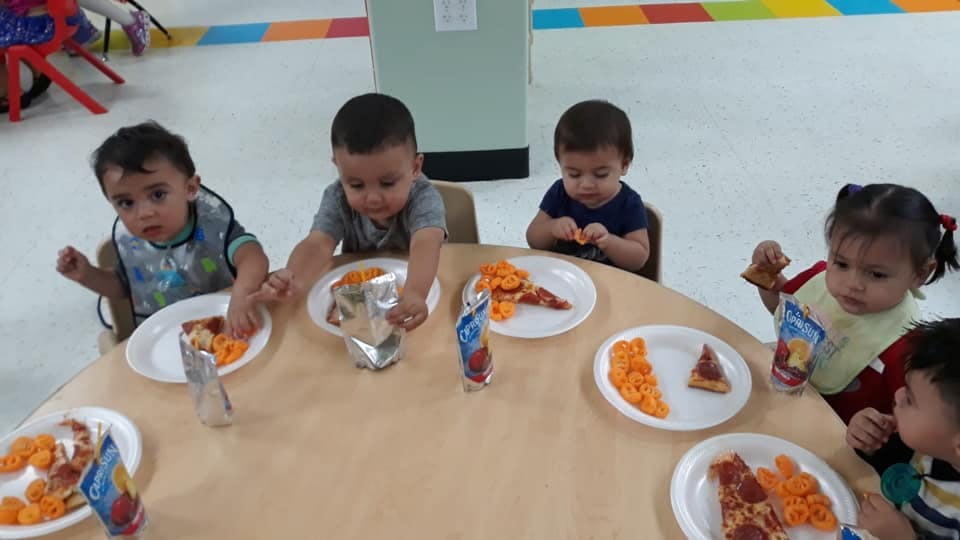 Children eating at a table in a classroom