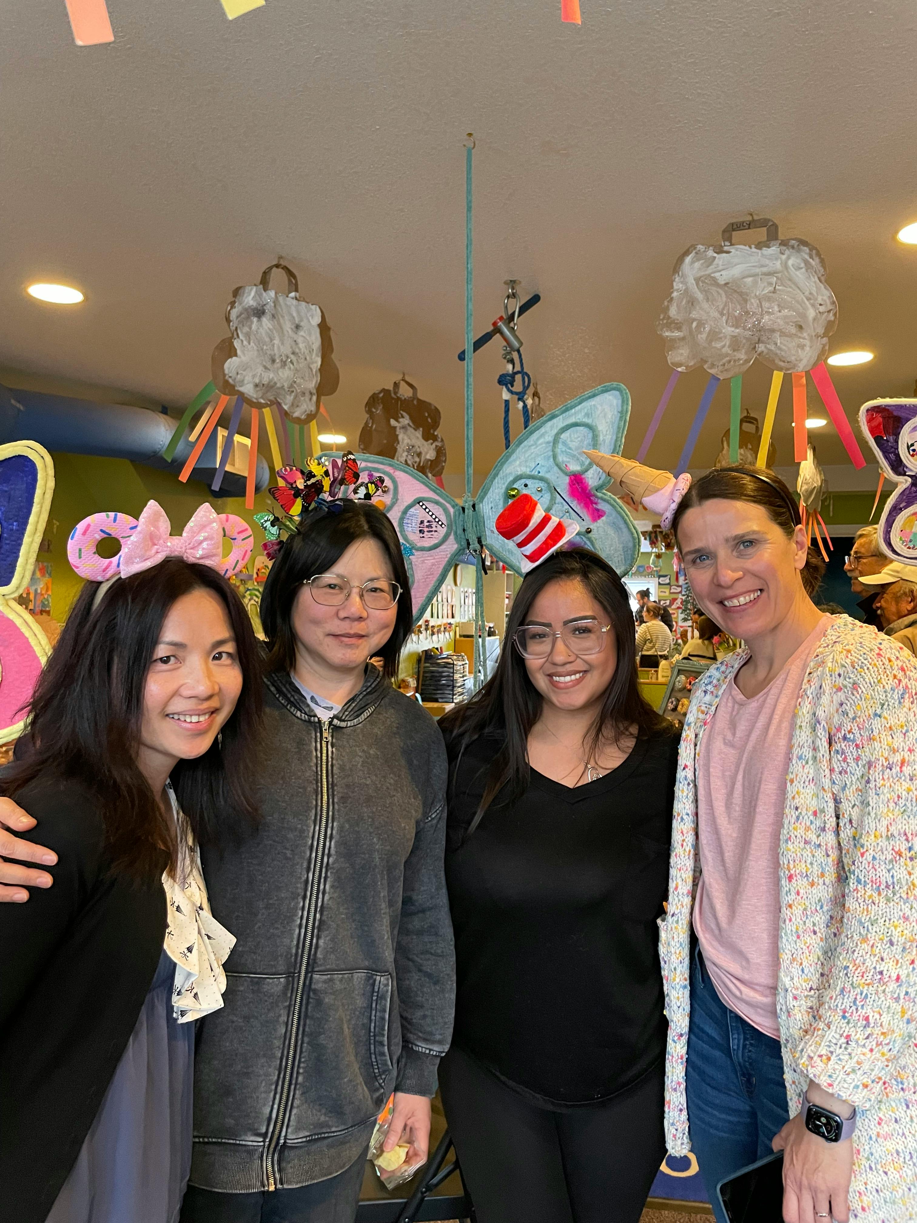 Four people posing for a photo indoors