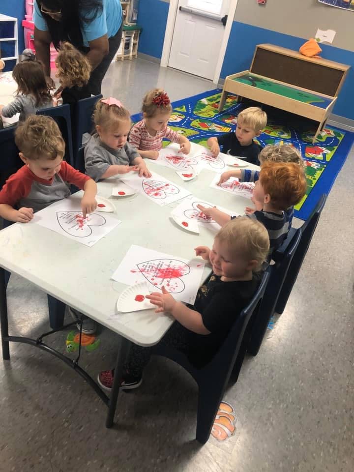 Children sitting at a table doing a craft activity