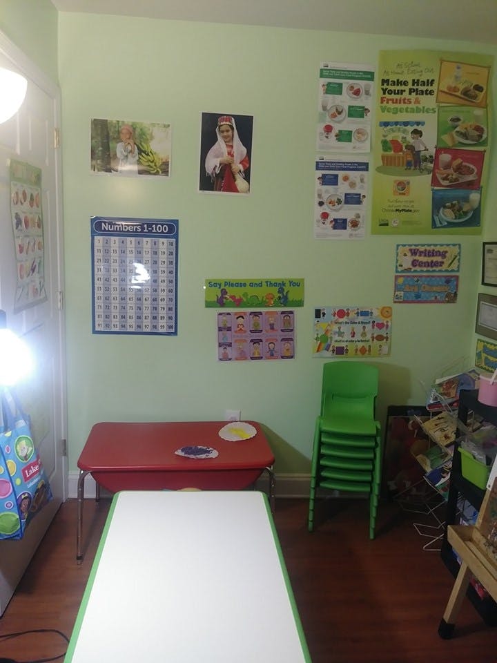 Classroom with posters on the wall, tables, and stacked green chairs