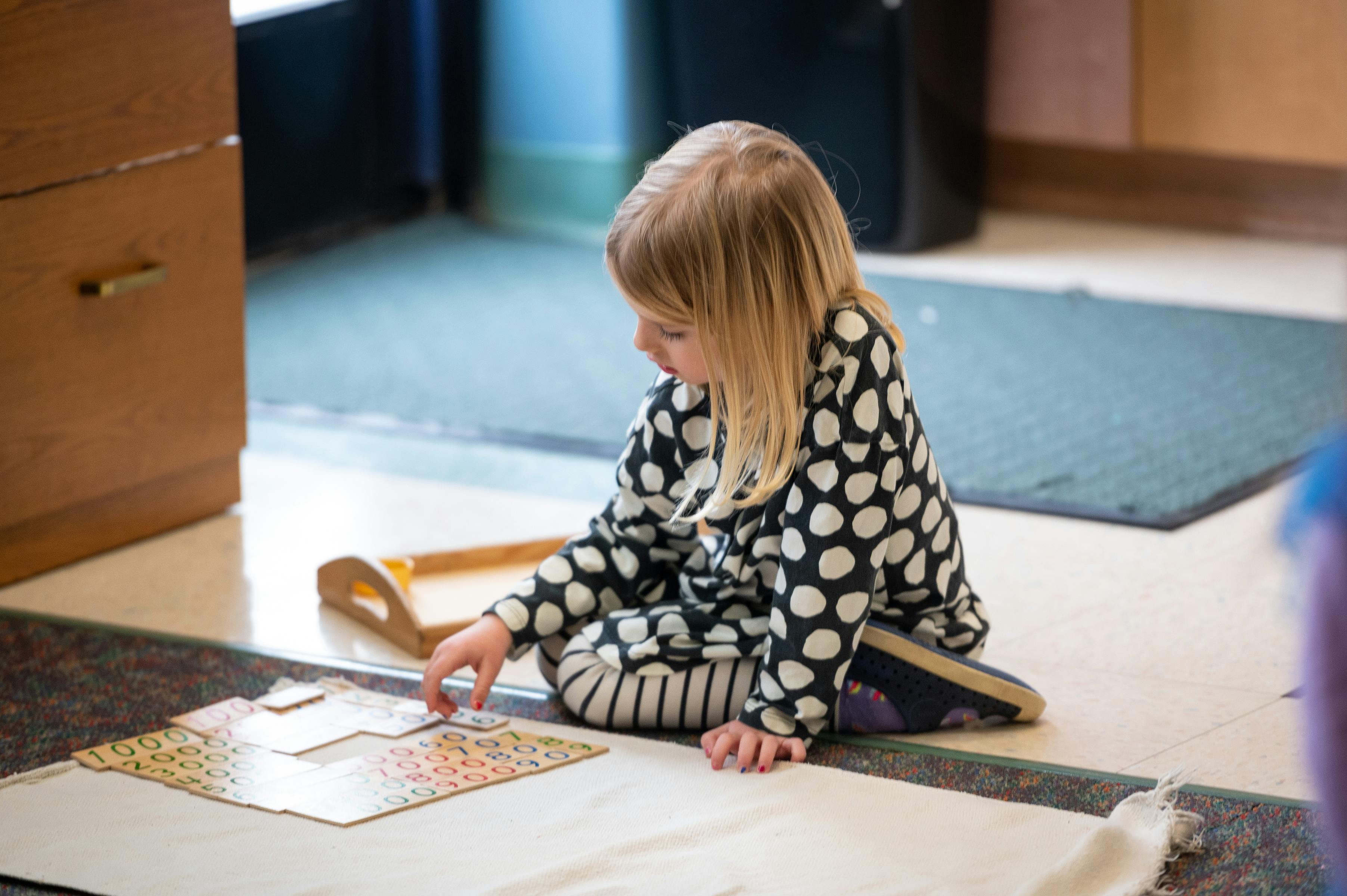Child sitting on floor playing with puzzle