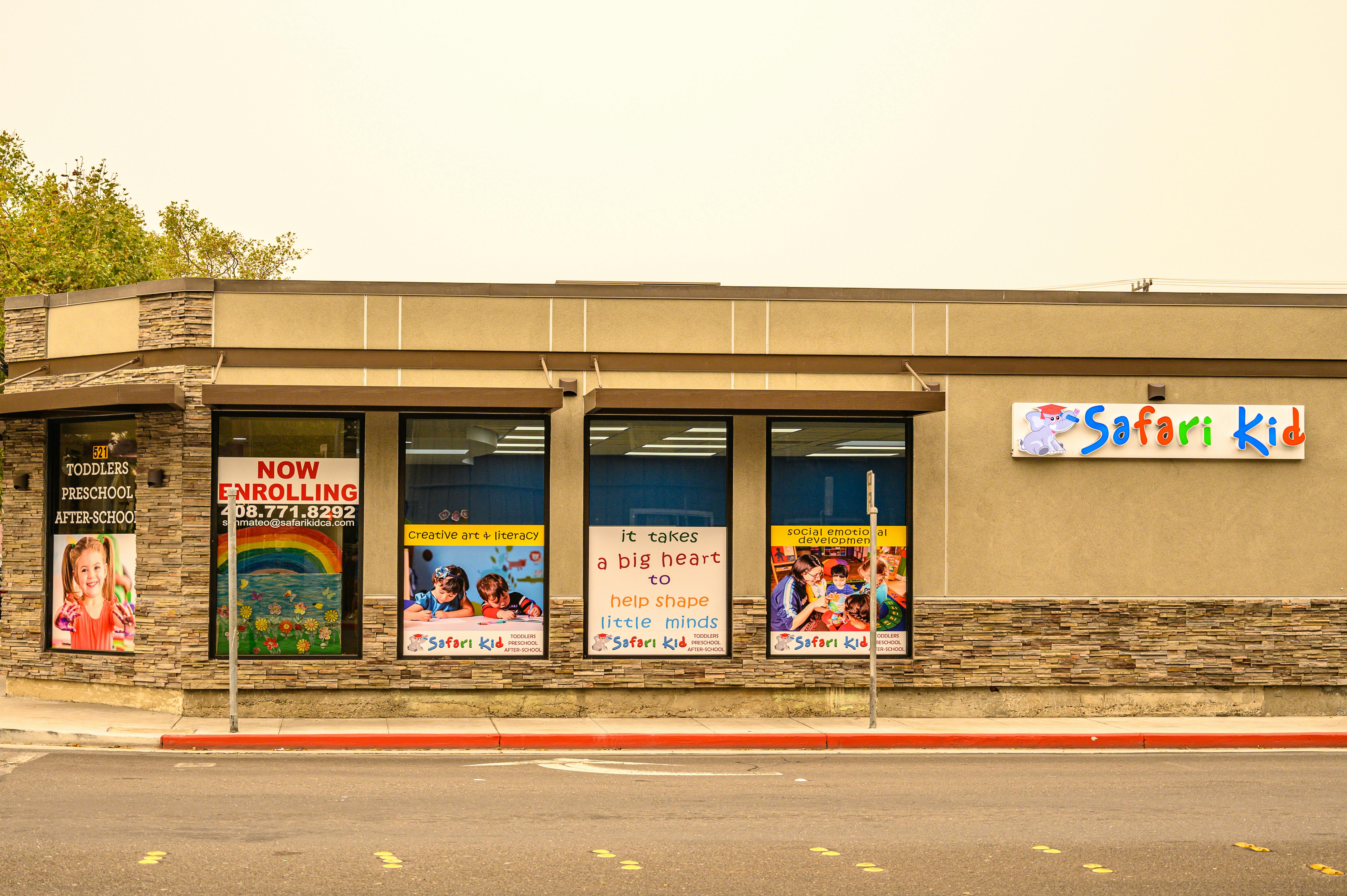 Building exterior with "Safari Kid" sign and window advertisements