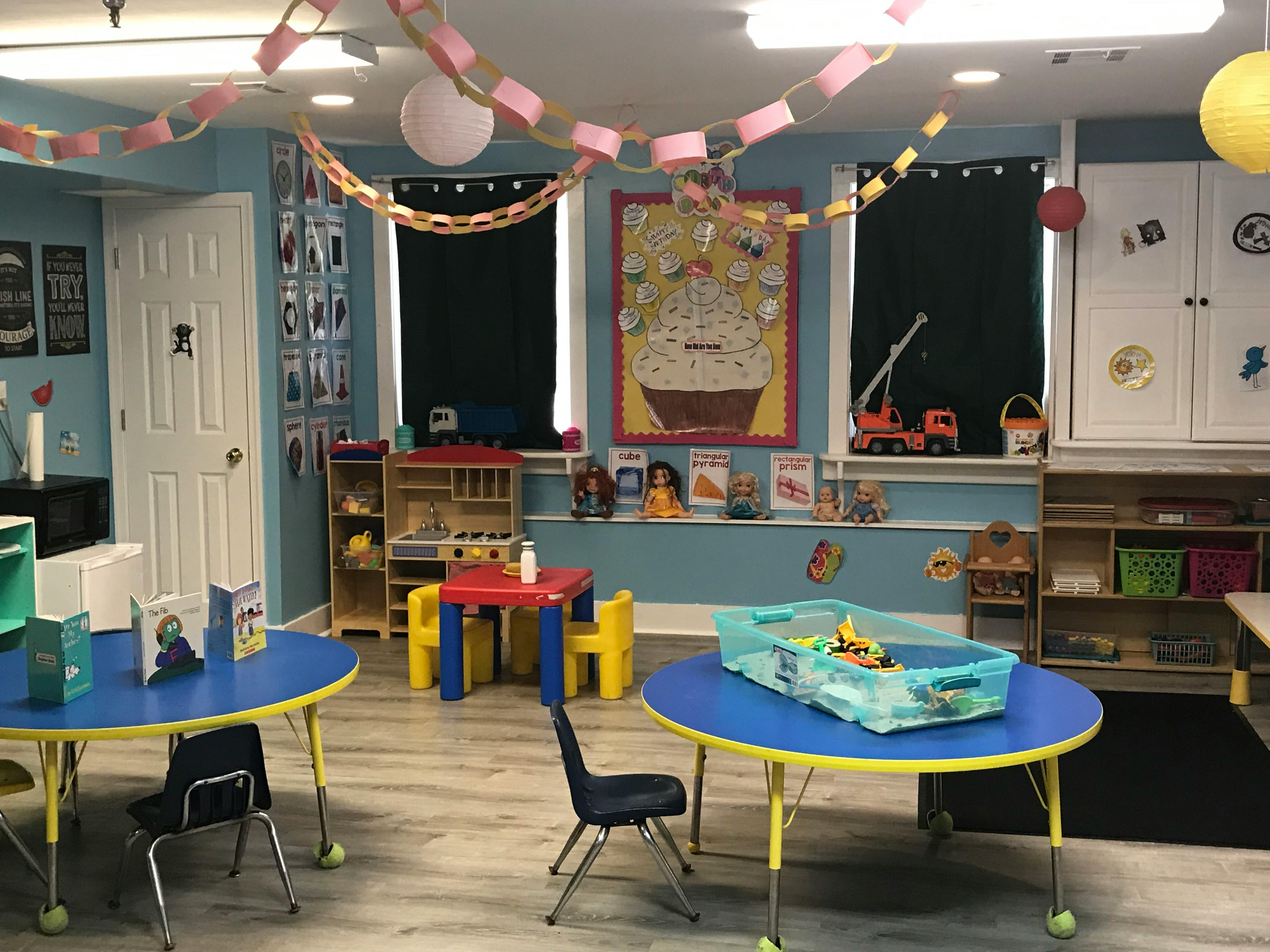 Classroom with small tables and chairs, decorated with paper chains
