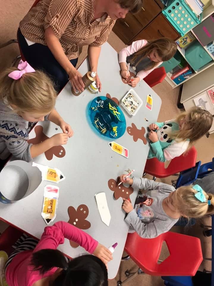 Adult and children making crafts at a table