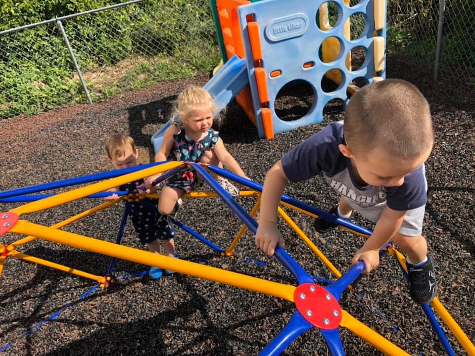 Three children climbing on a playground