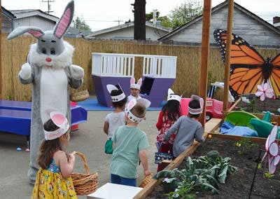 Person in bunny costume with children wearing bunny ears