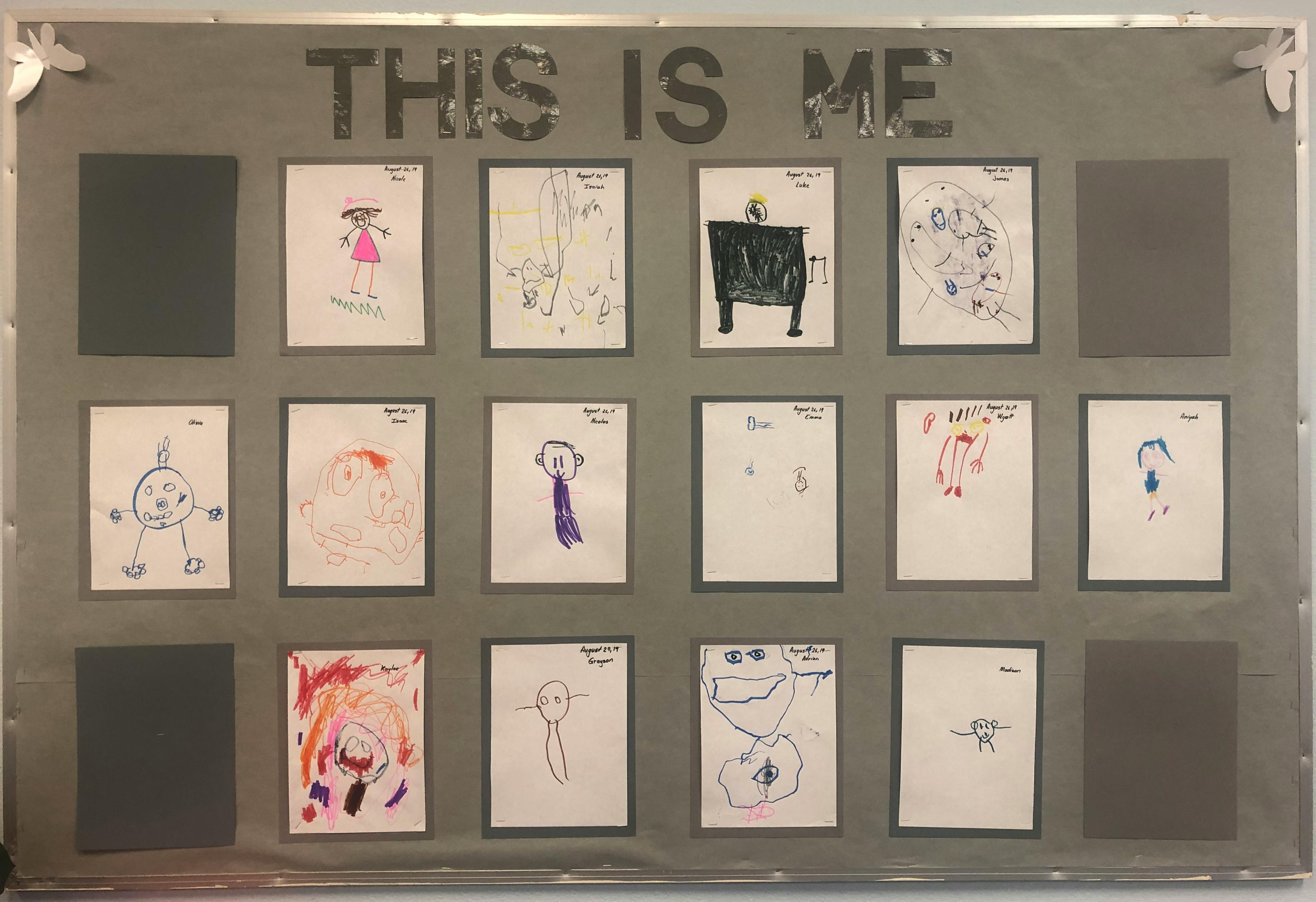Bulletin board with children's drawings and "THIS IS ME" text