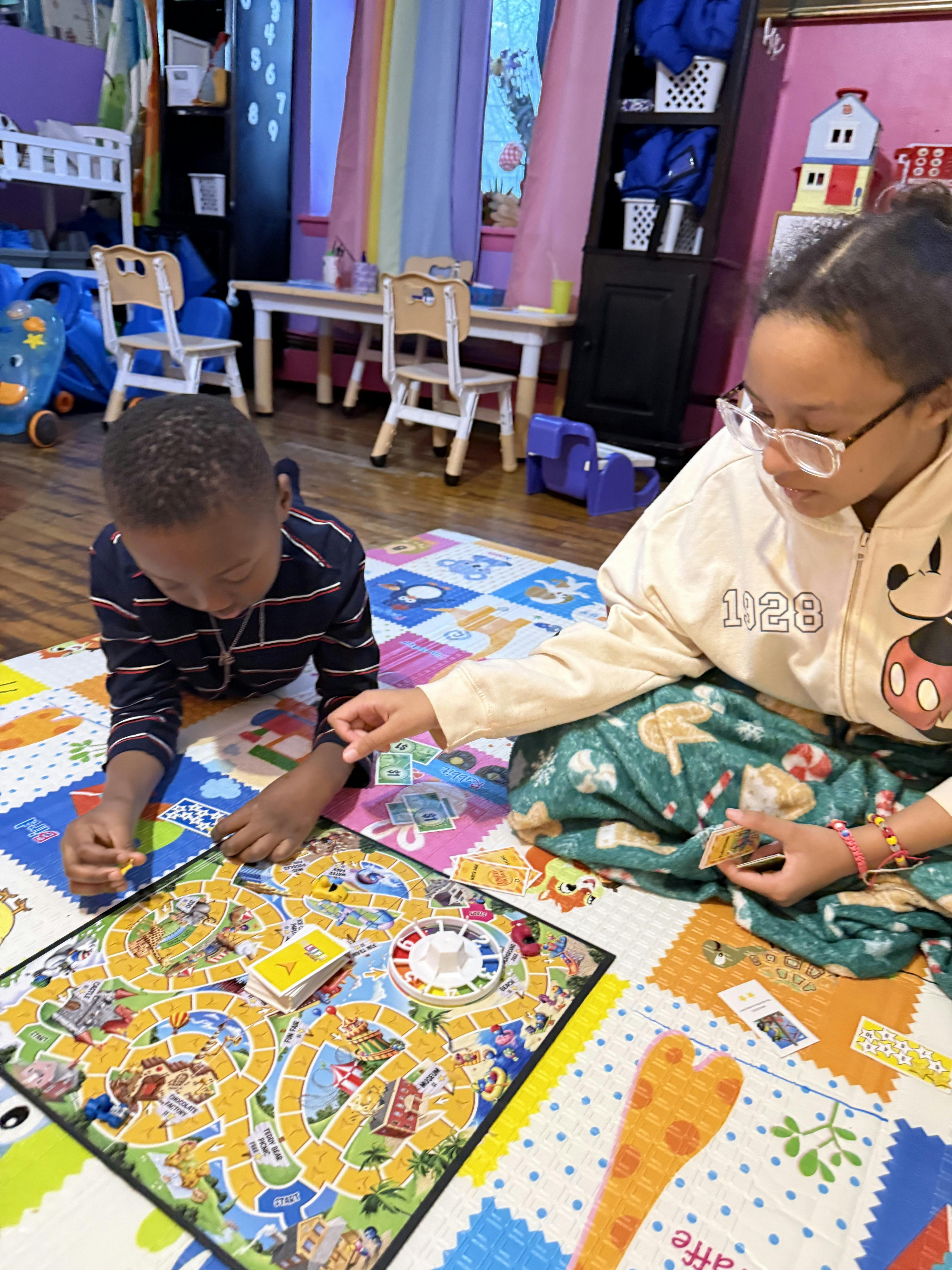 Two children playing a board game on the floor