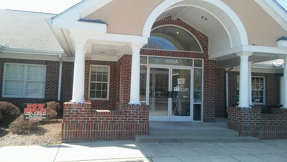 Front entrance of a brick building with white columns and an arched doorway