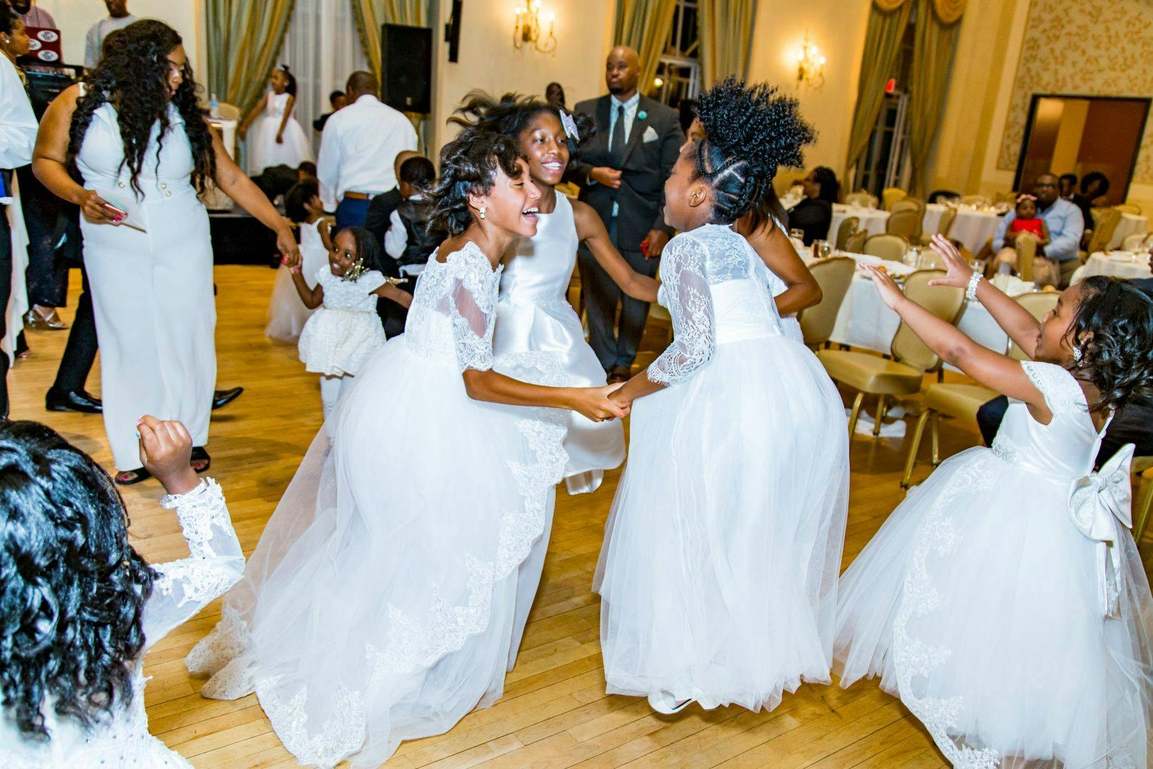 Children in white dresses dancing in a circle