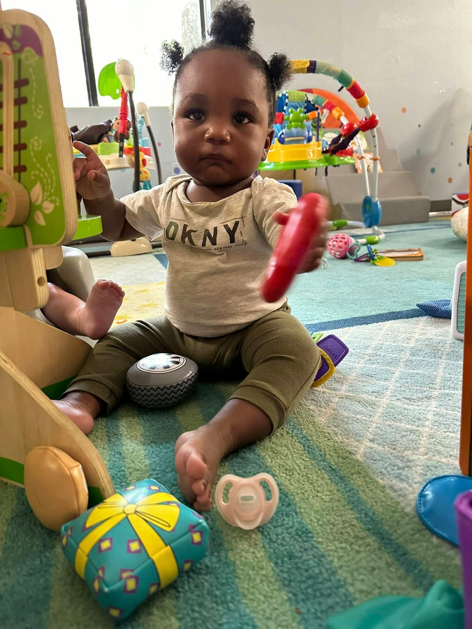 Child sitting on a rug playing with toys