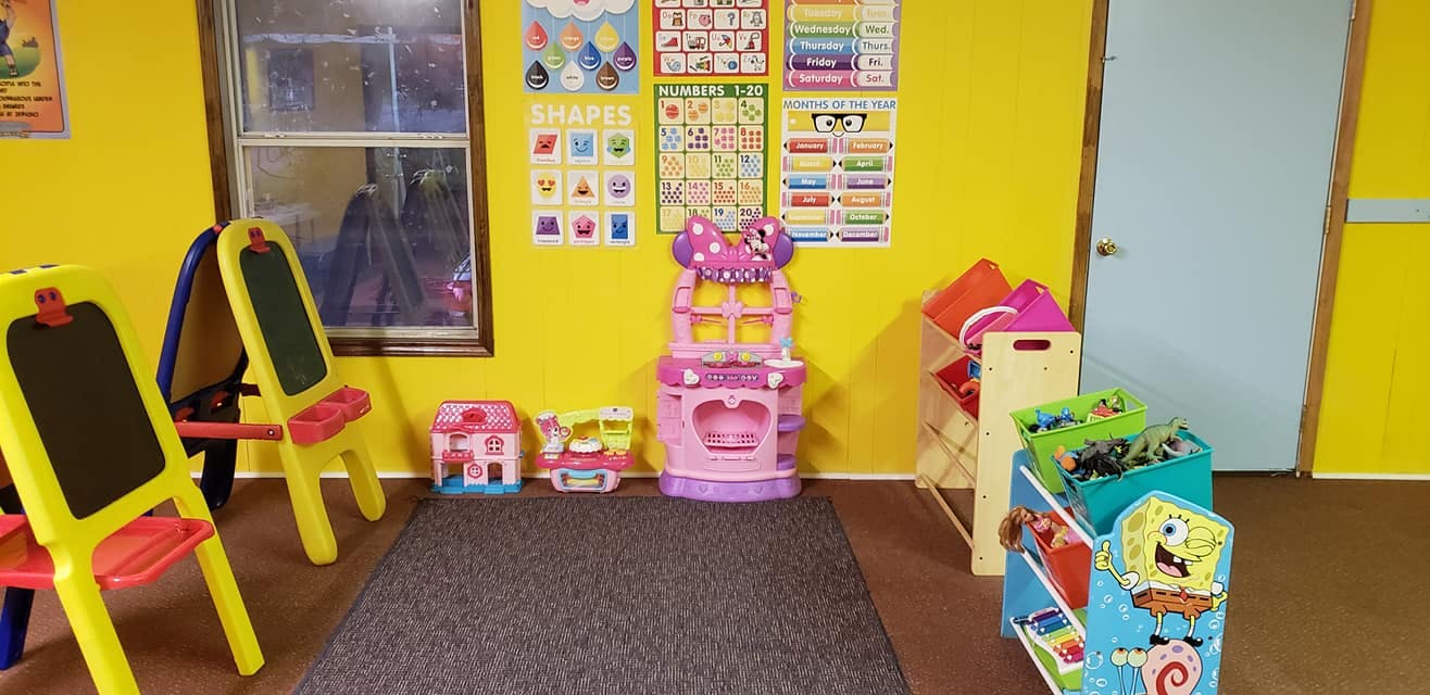 Playroom with easels, toy kitchen, and storage bins