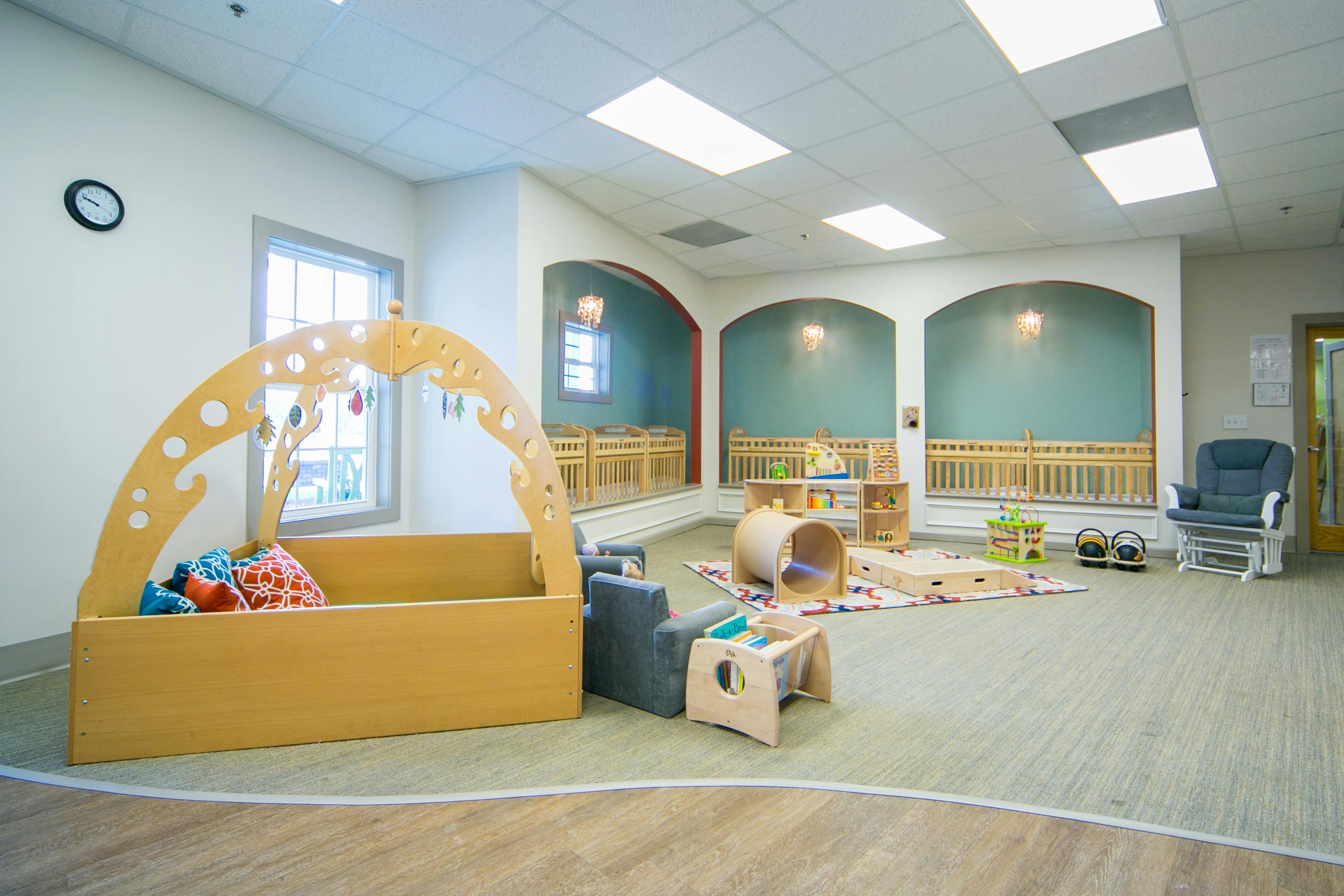 Playroom with a wooden playpen, small chairs, and a tunnel