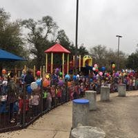 People standing in line at an outdoor event with balloons